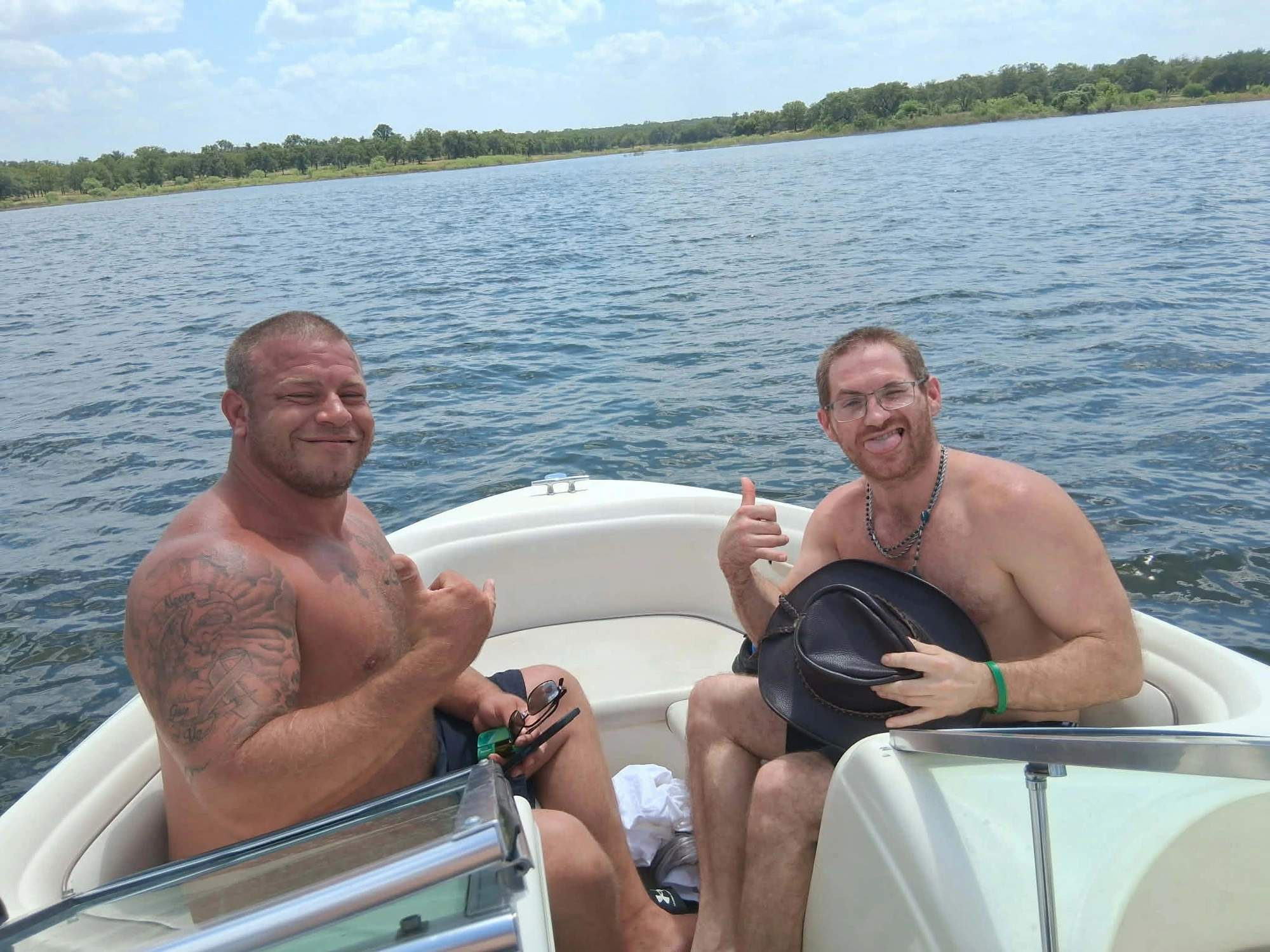 Two HIS House residents giving thumbs up on a boat during a house lake day