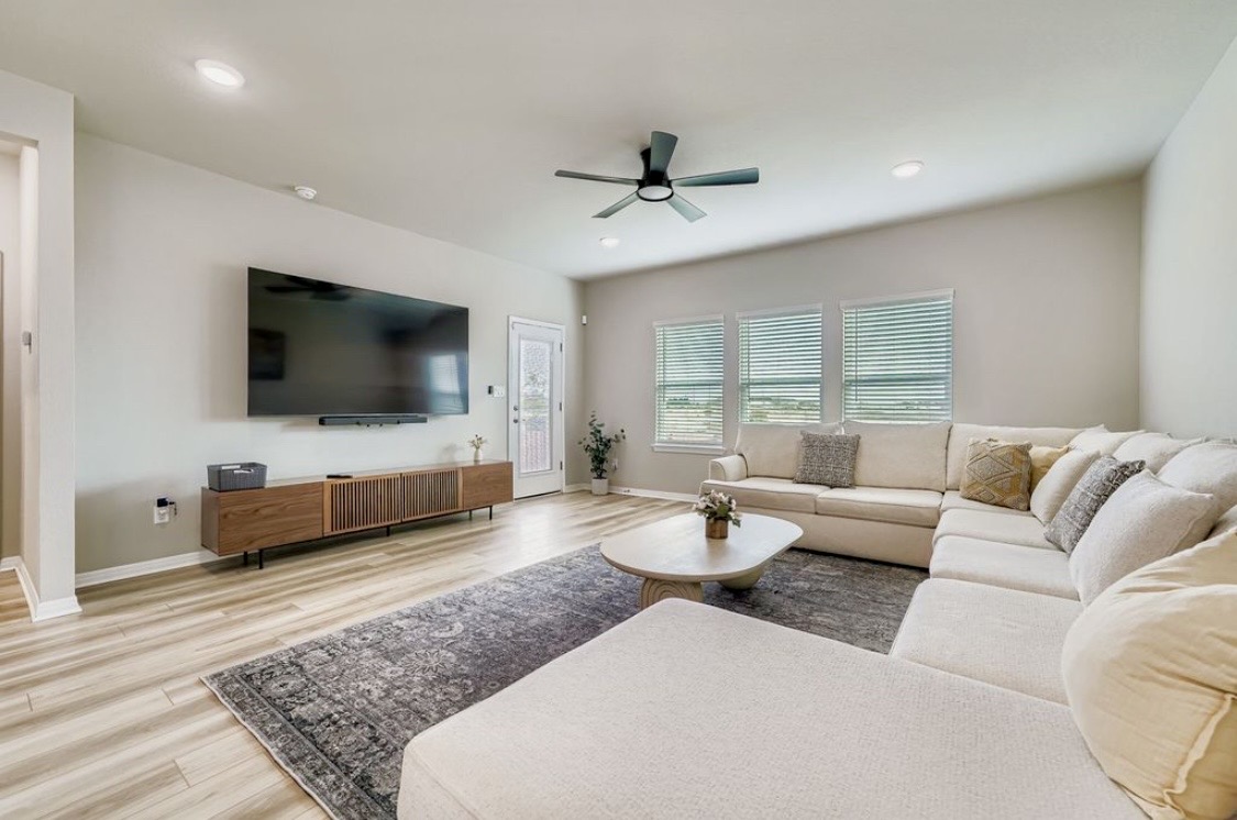 The bright shared living room at HIS House with a big sectional sofa